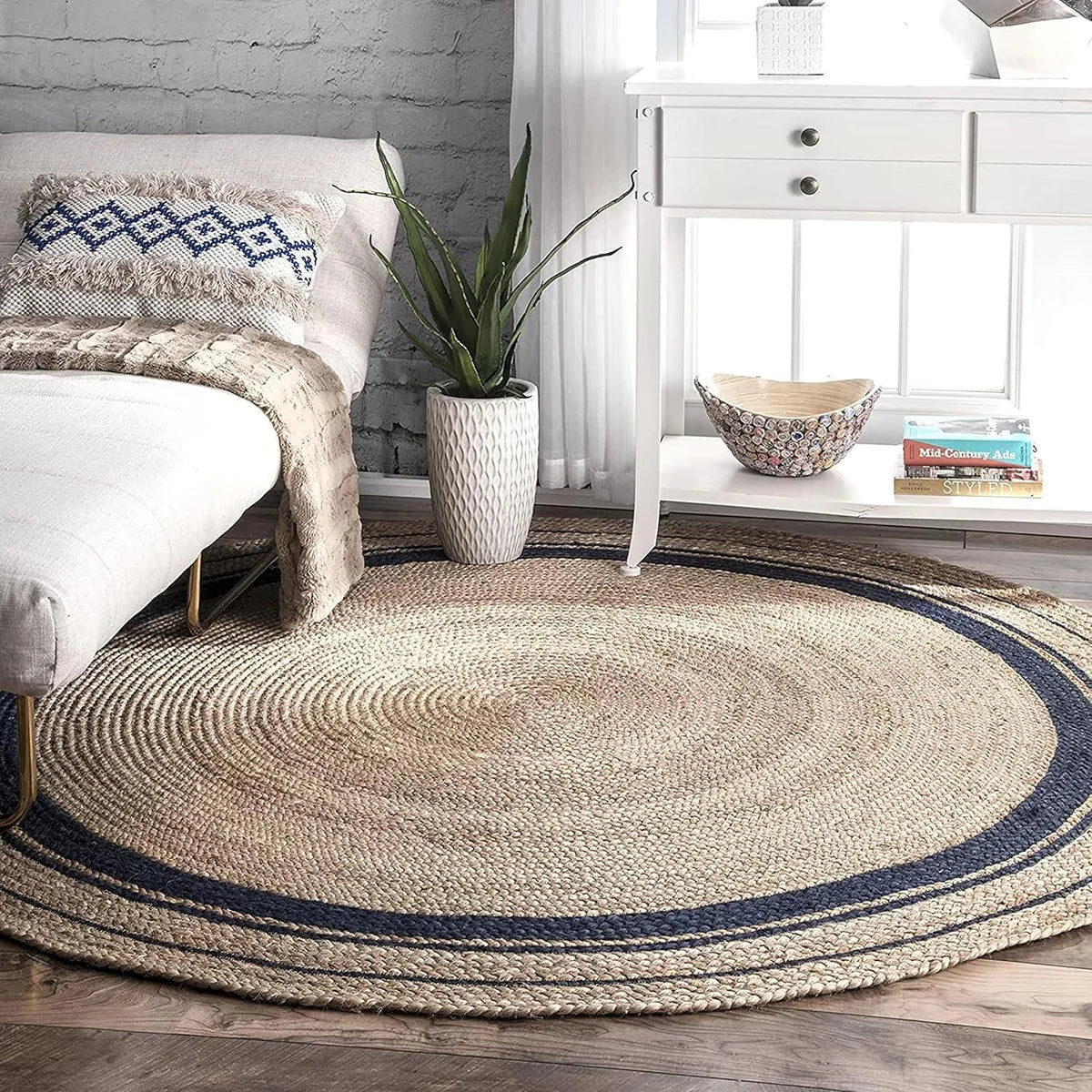 Natural beige round jute rug with black concentric braided border on white background